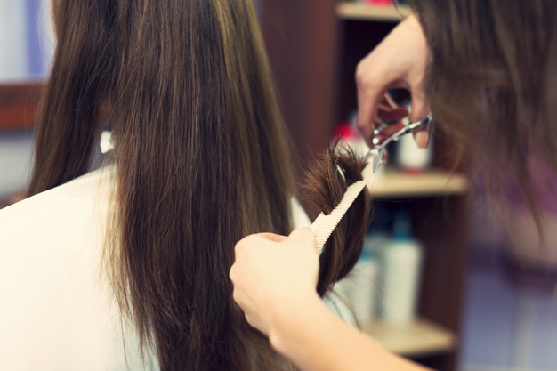 mujer cortando las puntas del pelo